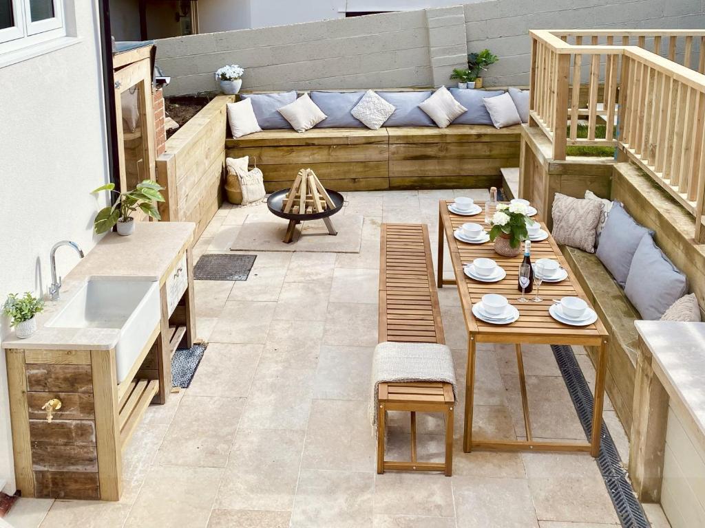a patio with a table and chairs and a couch at The Light Keepers Retreat in Cromer