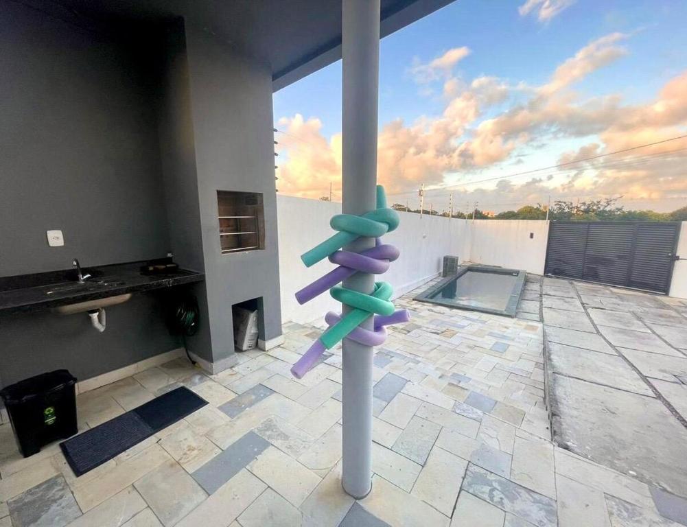 a pole in the middle of a room with a pool at Casa Almar Carapibus in Conde
