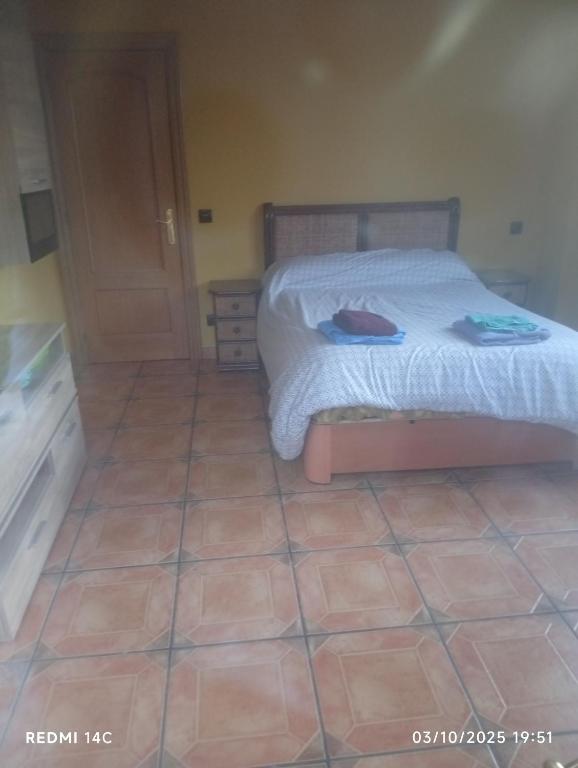 Un dormitorio con una cama y suelo de baldosas. en El refugio de Sam, en Burgos