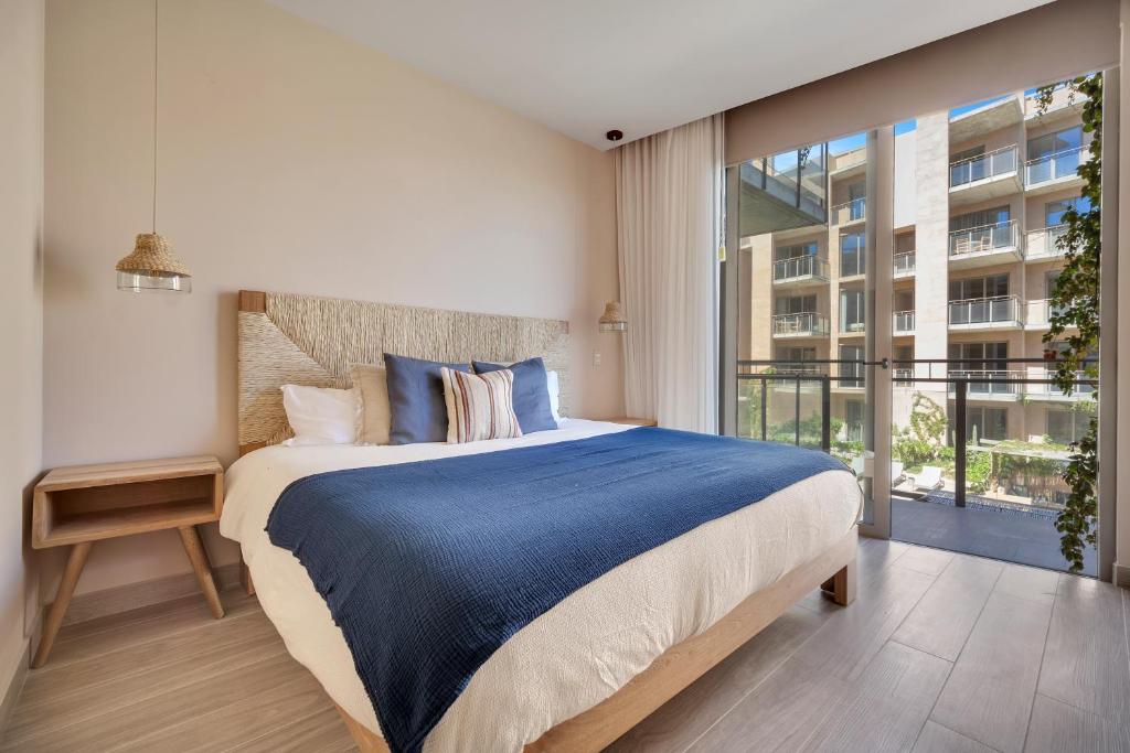 a bedroom with a large bed and a large window at Bohari Las Arenas in Cabo San Lucas