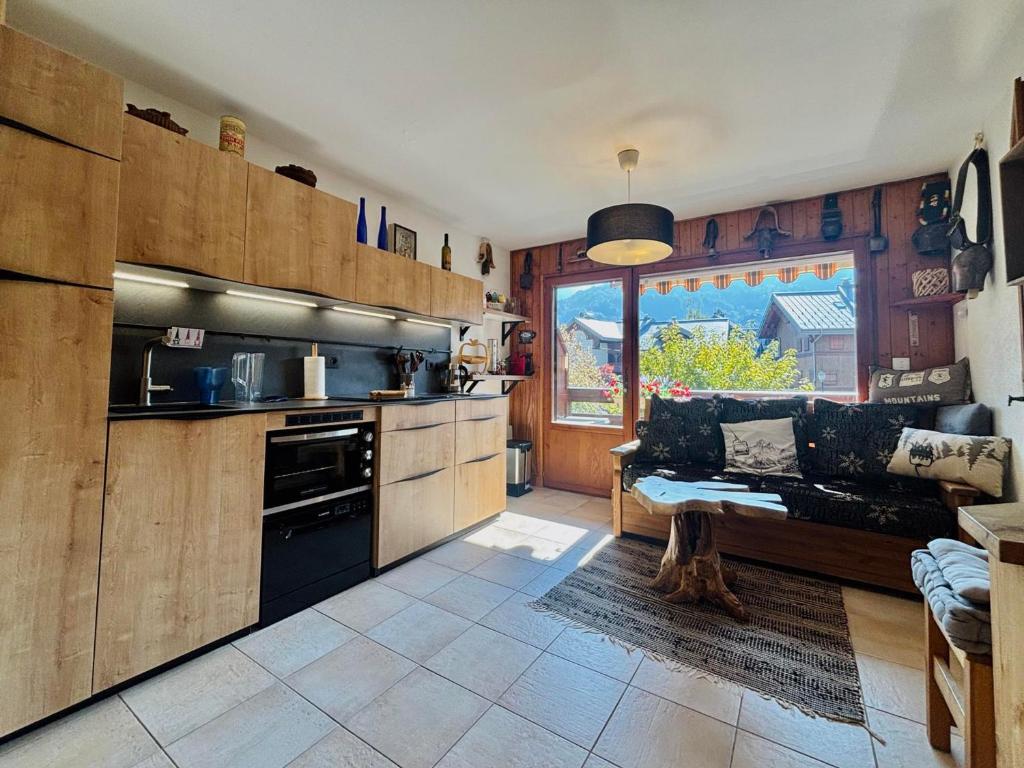 a living room with a couch and a kitchen at Appartement T3 rénové, lumineux, balcon et parking au centre du village de Samoëns - FR-1-624-73 in Samoëns