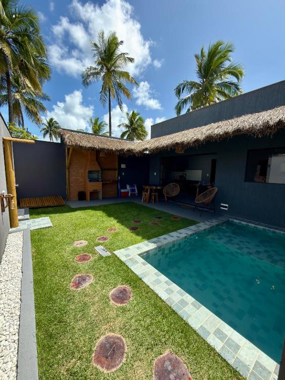 a backyard with a swimming pool and a house at Bangalô Miramar Maragogi in Maragogi
