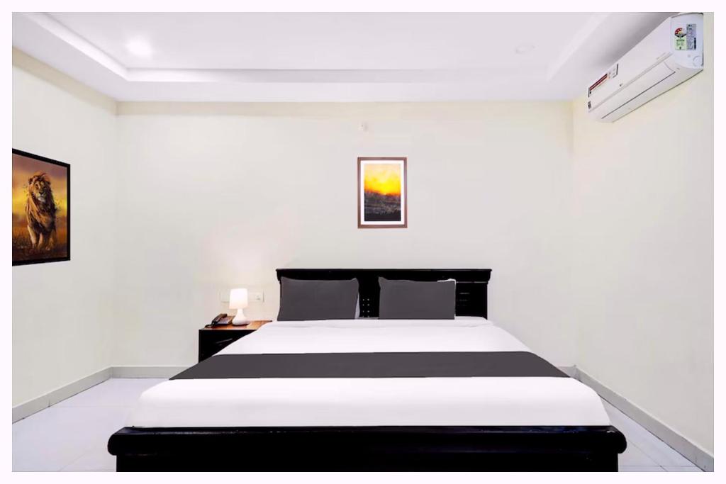 a white bedroom with a black and white bed at Hotel Mahabodhi Residency Near Railway Station-Fully Air Conditioning Hotel - Luxury & Spacious Room- A Top Rated Hotel in Cuttack