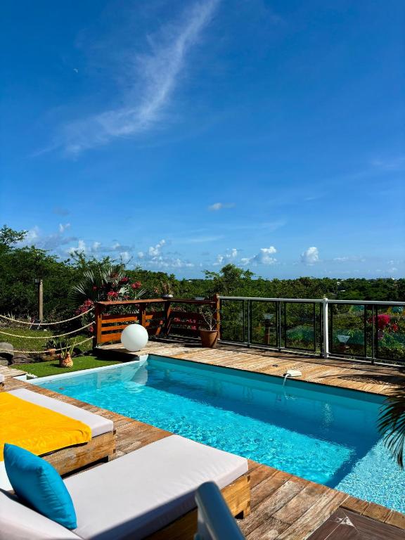 a swimming pool with a view of the jungle at Villa Iséa - Piscine privée & Terrasse Vue Mer in Le Gosier