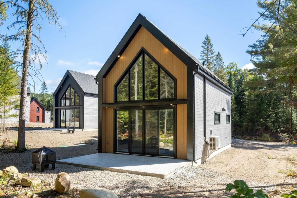 a house with large windows on the side of it at Mini-chalet #1 Chute-à-Bull St-Côme in Saint Come