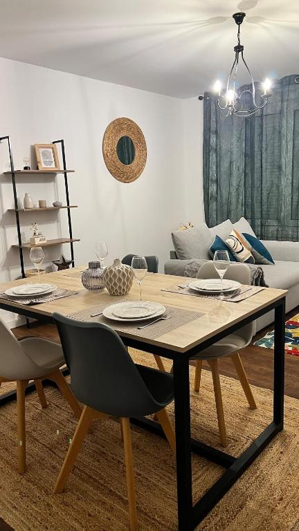 a dining room table with two chairs and a couch at L'Armonia en plein centre de Mordelles in Mordelles