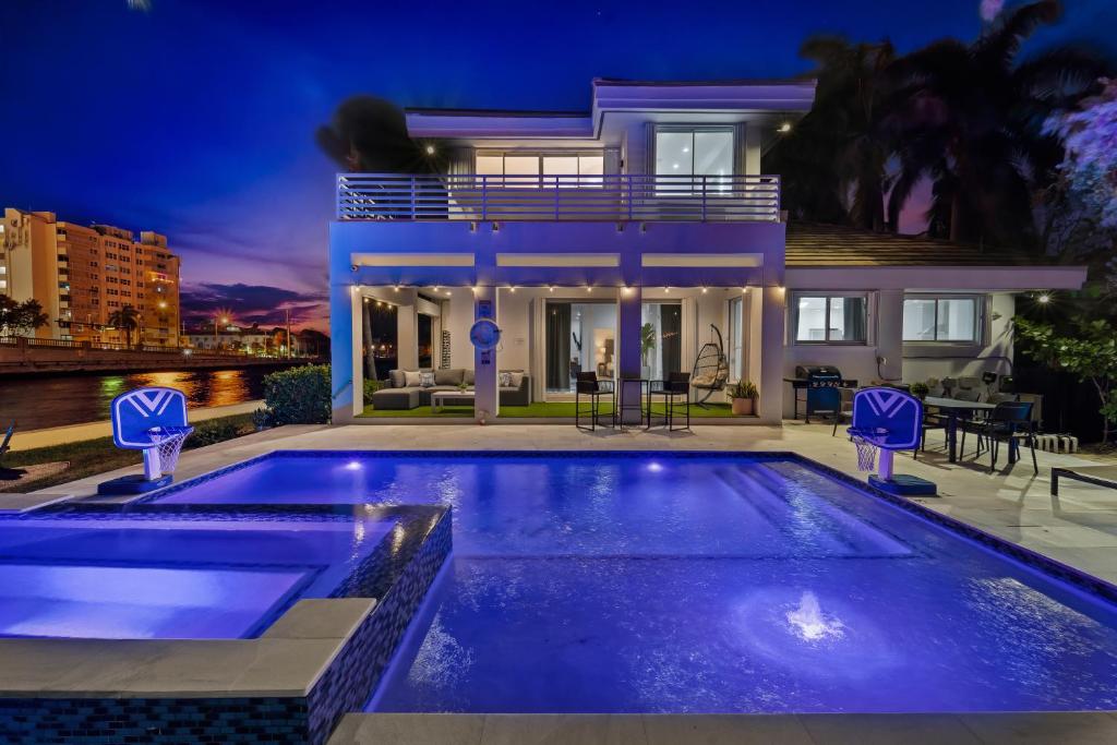 a swimming pool in front of a house at night at Villa Harrison . in Hollywood Beach