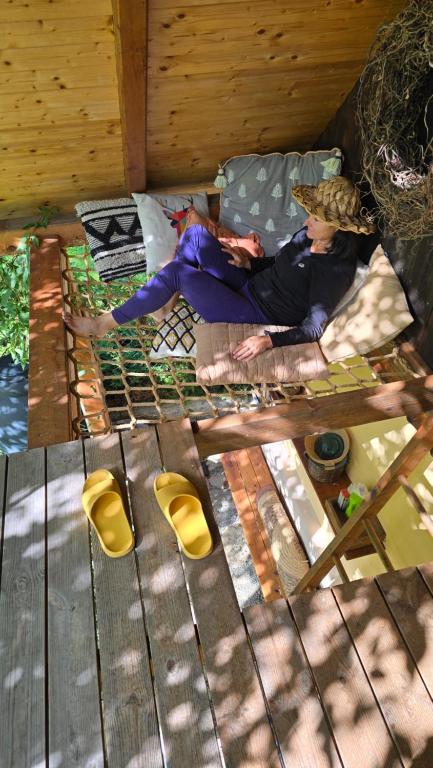 a person laying on a bed in a cabin at Kdebolotambolo chalupka in Belá