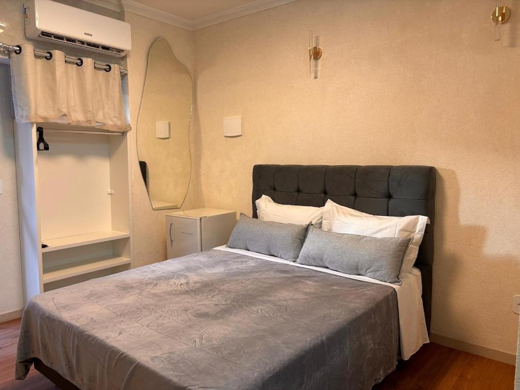 ein Schlafzimmer mit einem großen Bett und einem Spiegel in der Unterkunft Ste. 6 Premium na quadra da Praia do Forte in Škorak