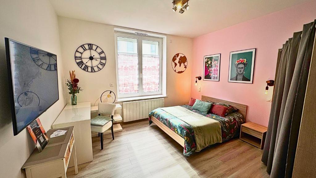 a bedroom with a bed and a clock on the wall at Beau Studio Neuf proche du centre et de Nausicaa in Boulogne-sur-Mer