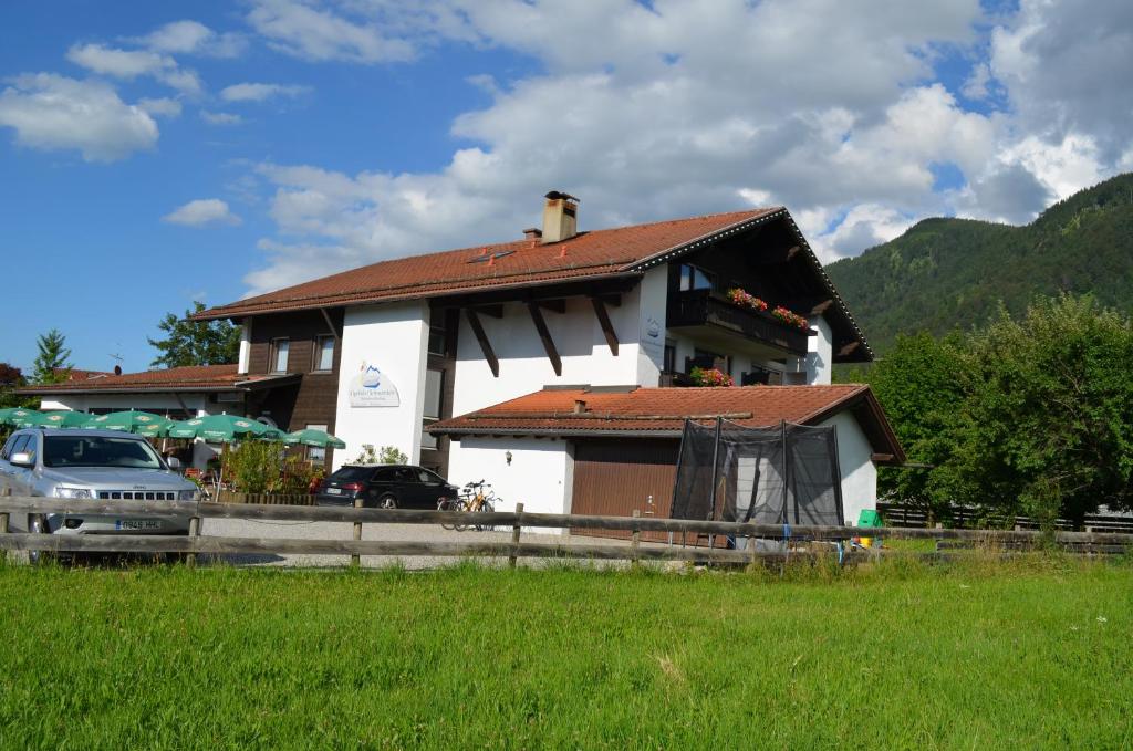 una casa con un coche aparcado delante de ella en Alpchalet Schwanstein, en Halblech