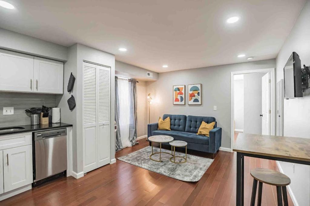 un soggiorno con un divano blu e una cucina di Modern and Stylish Center City 1BR - Perfect Location a Philadelphia