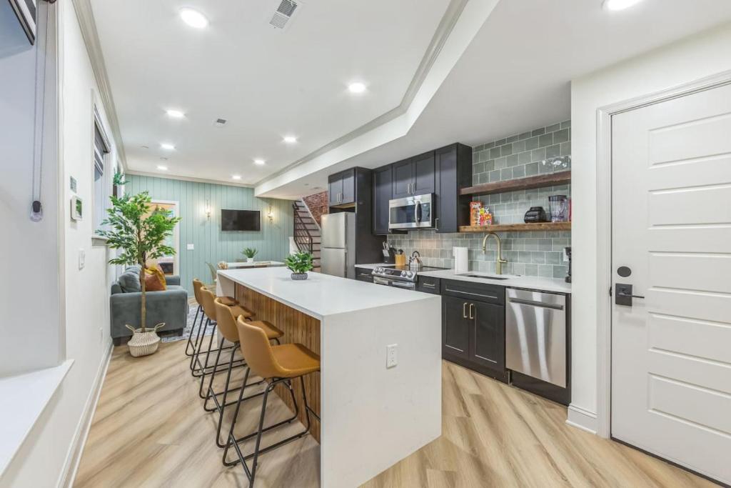 - une cuisine avec un comptoir blanc et des chaises dans l'établissement Bi-Level 2BR w Rooftop - Sleeps 12 - 10 min to DT, à Philadelphie
