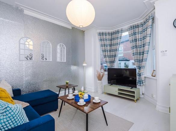 een woonkamer met een blauwe bank en een tv bij Sleep7, Pool Table, TTennis, Free Parking, 3BR in Manchester