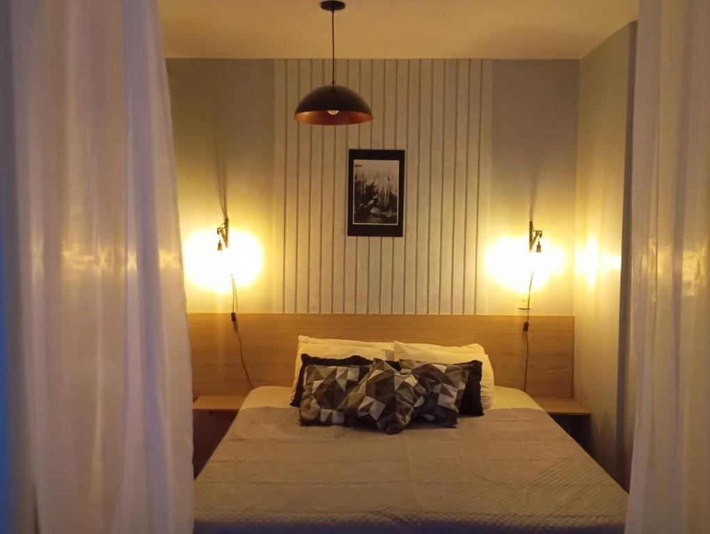 Un dormitorio con una cama con dos luces. en Golden Dolphin Express 403, en Caldas Novas
