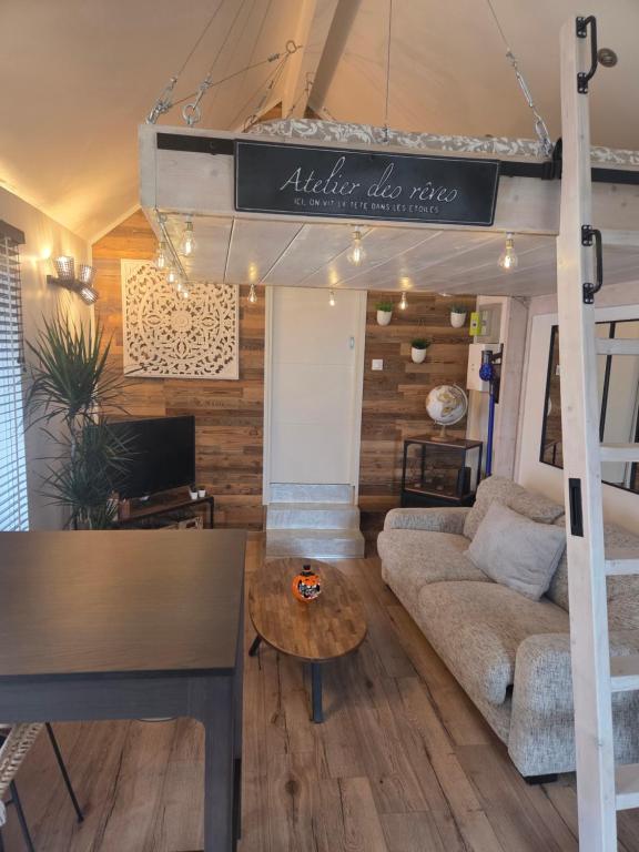 een woonkamer met een hoogslaper en een bank bij Le Perchoir " Une nuit suspendu dans le temps" in Chessy