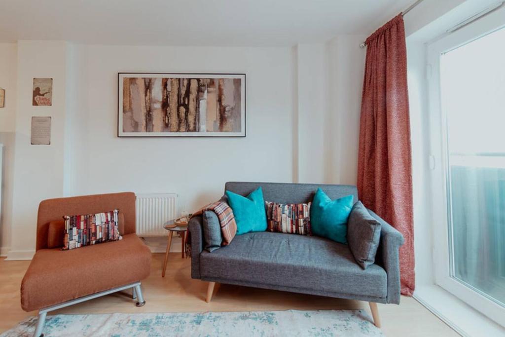a living room with a couch and a chair at The Diickens Den - Stylish Rochester 1BR Flat - Sleeps 4 - Walk to High St, Castle & Station with Secured Parking - Contractor - Friendly and Ideal for Long Stays in Rochester