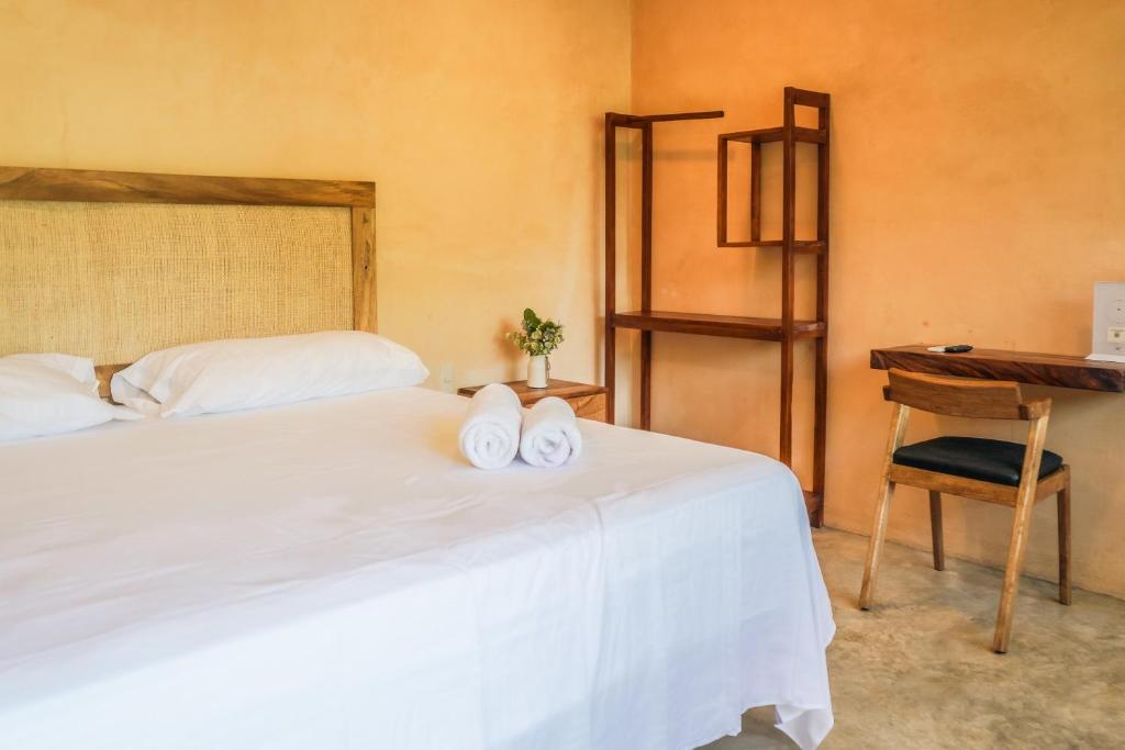 ein Schlafzimmer mit einem Bett mit zwei Handtüchern darauf in der Unterkunft Habitación 3 Casa Eve in Brisas de Zicatela
