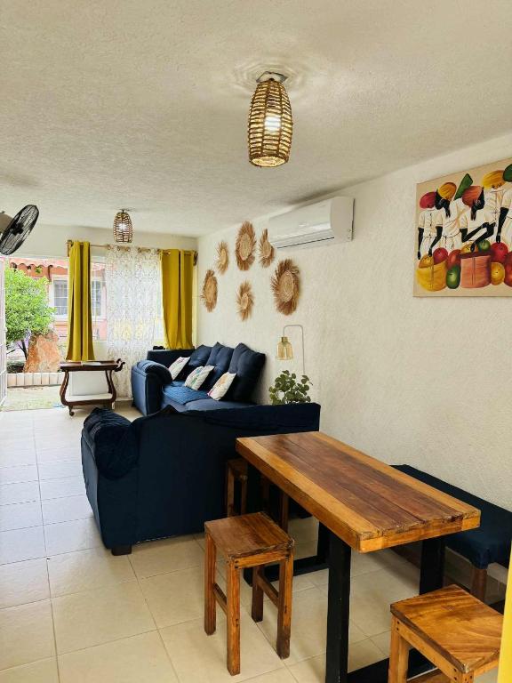 a living room with a blue couch and a wooden table at Casa con alberca cerca de playas in Ixtapa