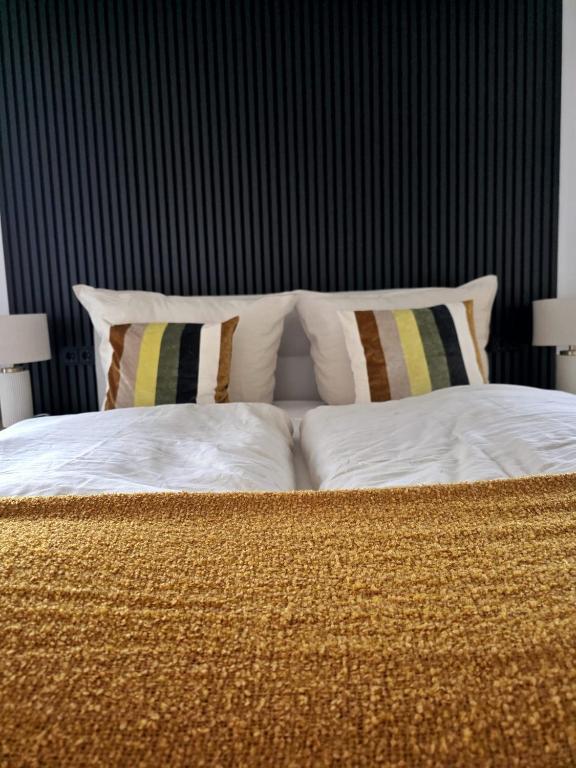 Una cama con sábanas blancas y almohadas en una habitación. en Ferienhaus Lyś, en Lauta