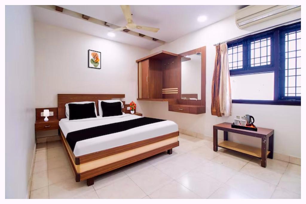 a bedroom with a large bed and a table at Hotel Kanika Palace Near Railway Station in Cuttack