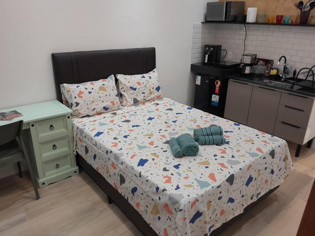 une chambre avec un lit et une table et une cuisine dans l'établissement Studio em vila centenária em Copacabana, à Rio de Janeiro
