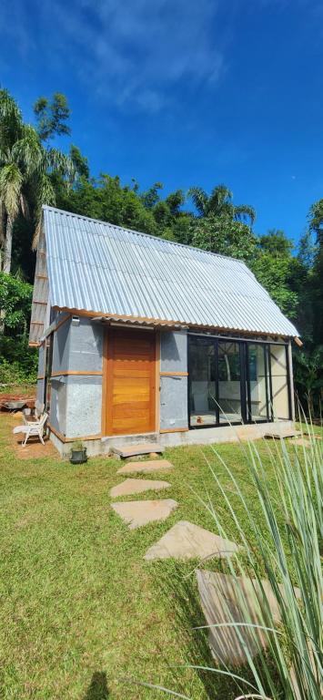 a small house with a wooden door in a yard at Eco Bamboo House in Florianópolis