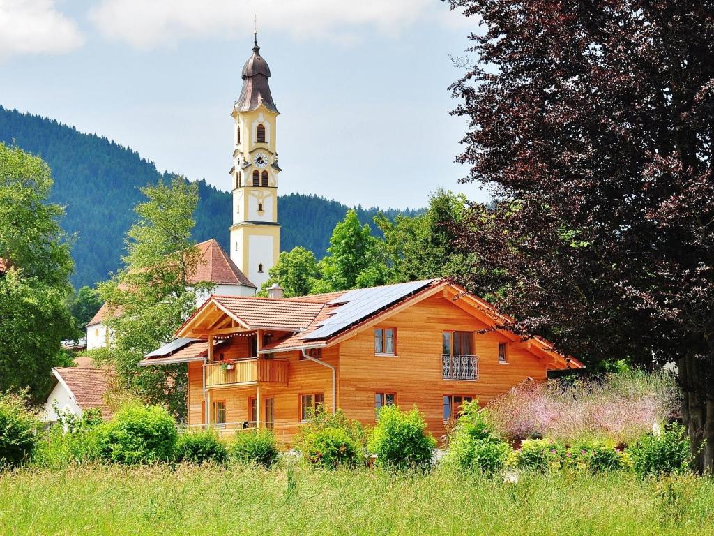 a wooden building with a clock tower in the background at Haus Sonnenau in Pfronten