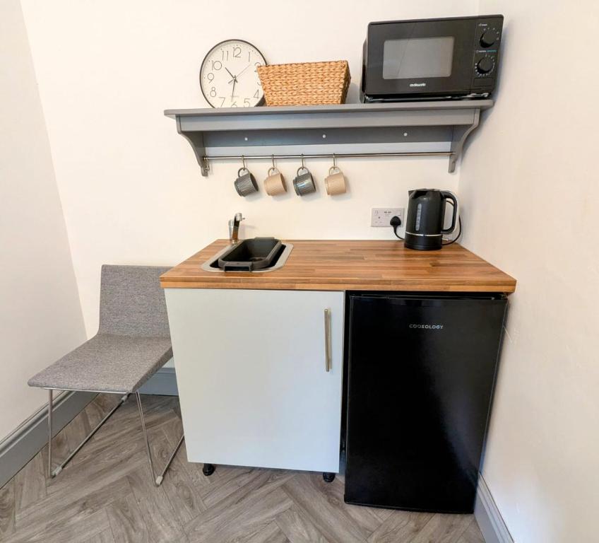 Una pequeña cocina con fregadero y microondas. en Private Ensuite Room, en Nantwich