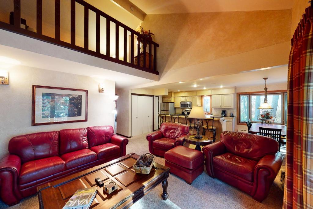 een woonkamer met rode lederen meubels en een keuken bij Creekside East 1 in Mid Vail