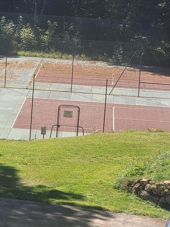 einen Tennisplatz mit einem Netz darüber in der Unterkunft Au petit montagnard in Les Rousses
