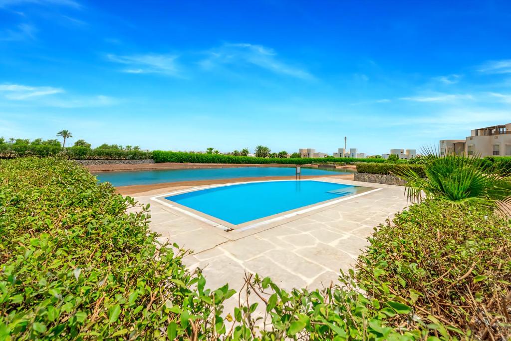 a swimming pool in a yard with bushes at Luxury Stays in Cyan El Gouna in Hurghada