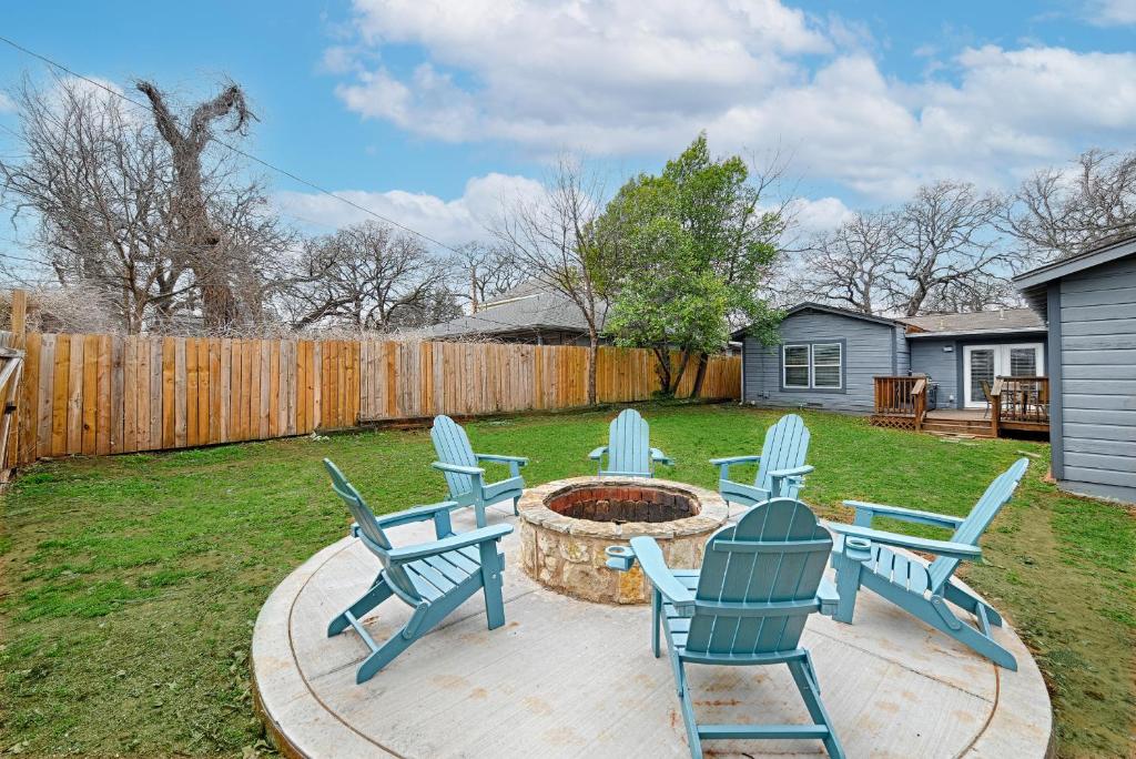 a group of blue chairs sitting around a fire pit at Daydream on Elm St - Dream City Retreats in Arlington