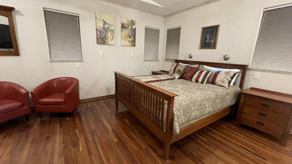 a bedroom with a bed and a chair at R and R Hideaway Suite in Fairbanks