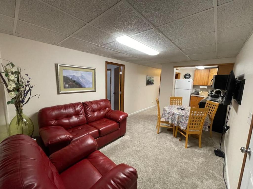 Una sala de estar con un sofá de cuero y una mesa. en Moose 2 bedroom lower, close to downtown, en Slaterville
