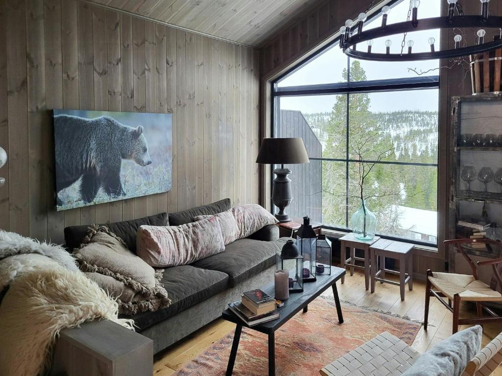 a living room with a bear painting on the wall at Modern Cabin In Norefjell With Sauna in Surteberg