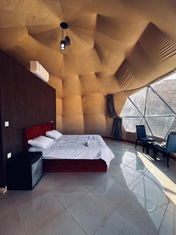 a bedroom with a bed in a large room at Rum Awaad luxury camp in Wadi Rum