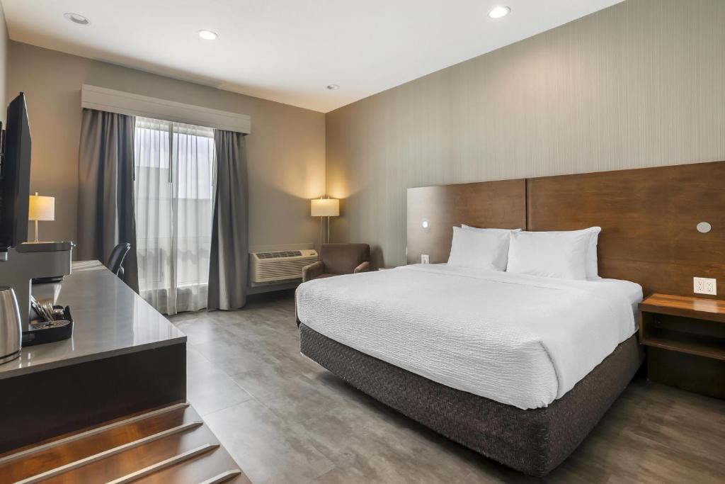 a hotel room with a bed and a desk at Best Western Plus East Side in Saskatoon