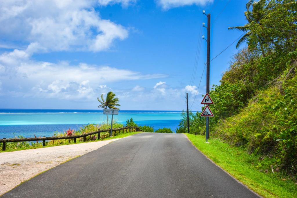 an empty road with the ocean in the background at HUAHINE - Room Manava Hoe in Faie