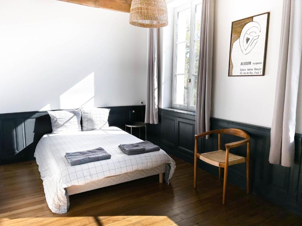 una camera da letto con un letto e una sedia di Les Jardins de La Cité 60m2 et parking gratuit a Digione