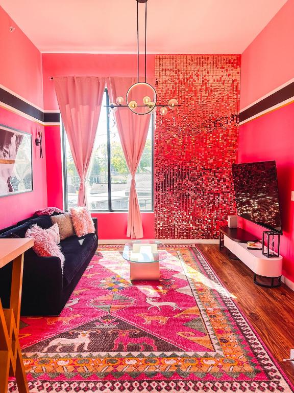 Hotel Dolly's Glam Getaway - Glittering Gem Near Broadway, a living room with pink walls and a black couch at Dolly's Glam Getaway - Glittering Gem Near Broadway in Nashville