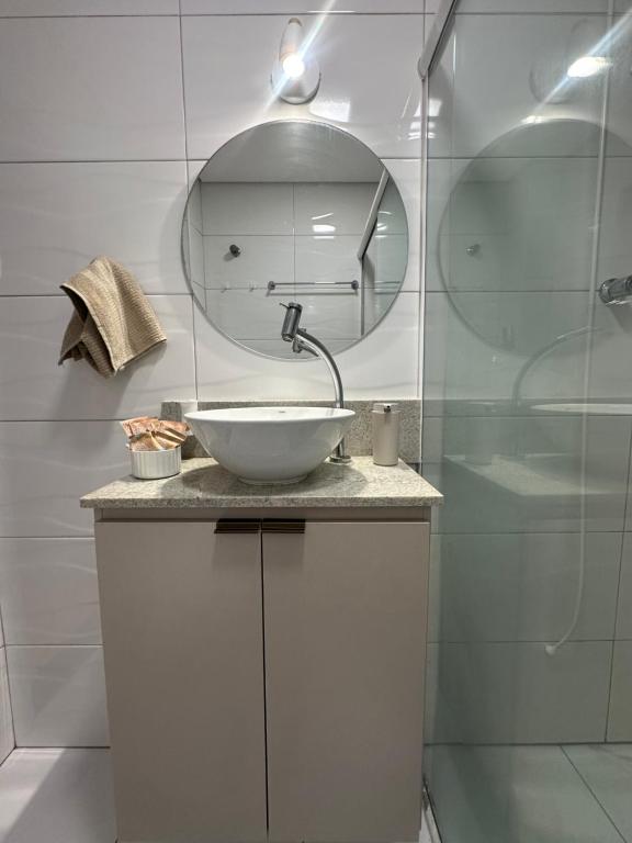 a bathroom with a white sink and a mirror at Apartamento pé na areia in Santos