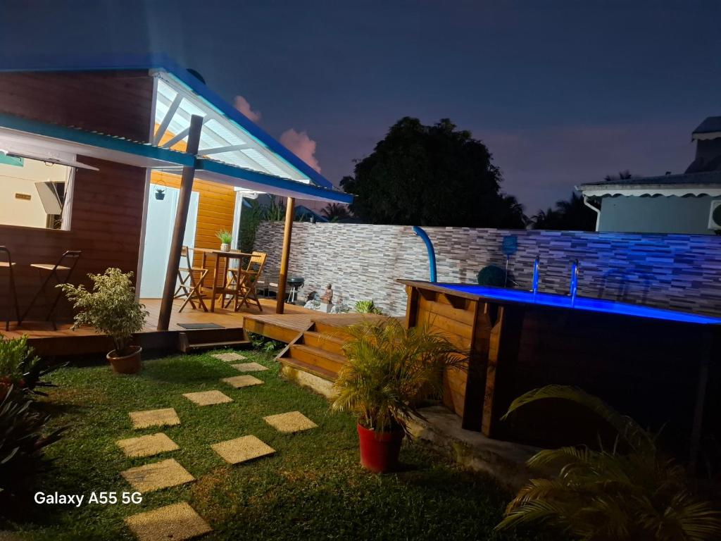 a backyard of a house at night with a patio at Bungaillou in Lamentin