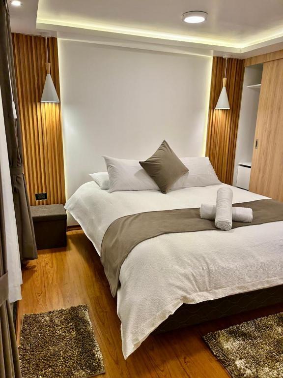 a bedroom with a large bed with white sheets at Hesed Hospedaje in Riobamba