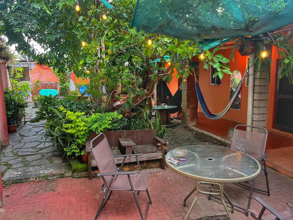 a patio with a table and chairs under a tree at Casa isabel in Santa Ana