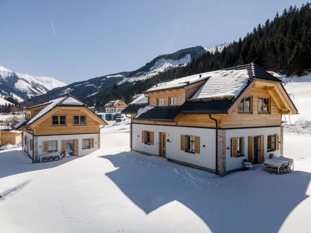 a house in the snow with mountains in the background at Haus Elau in Donnersbachwald