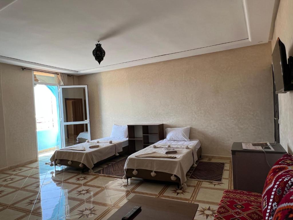 a room with two beds and a living room at Mirleft Beach in Mirleft