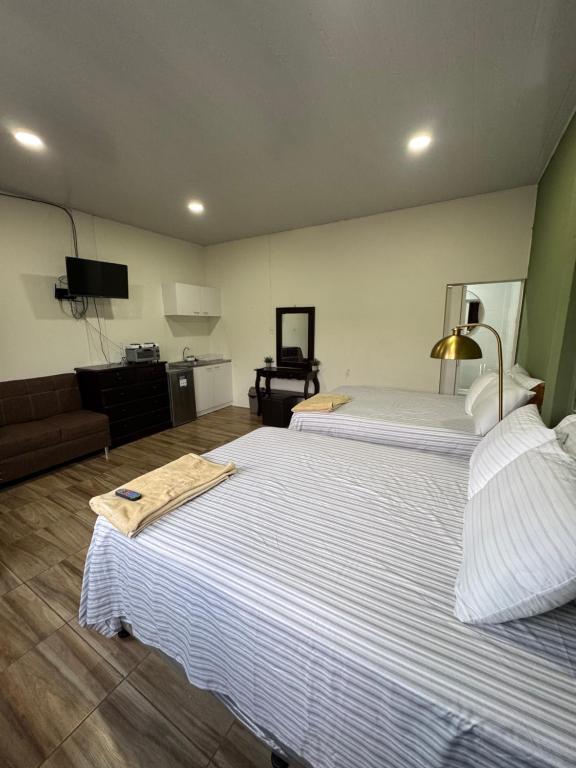 a hotel room with two beds and a couch at Emmitas room in Juayúa