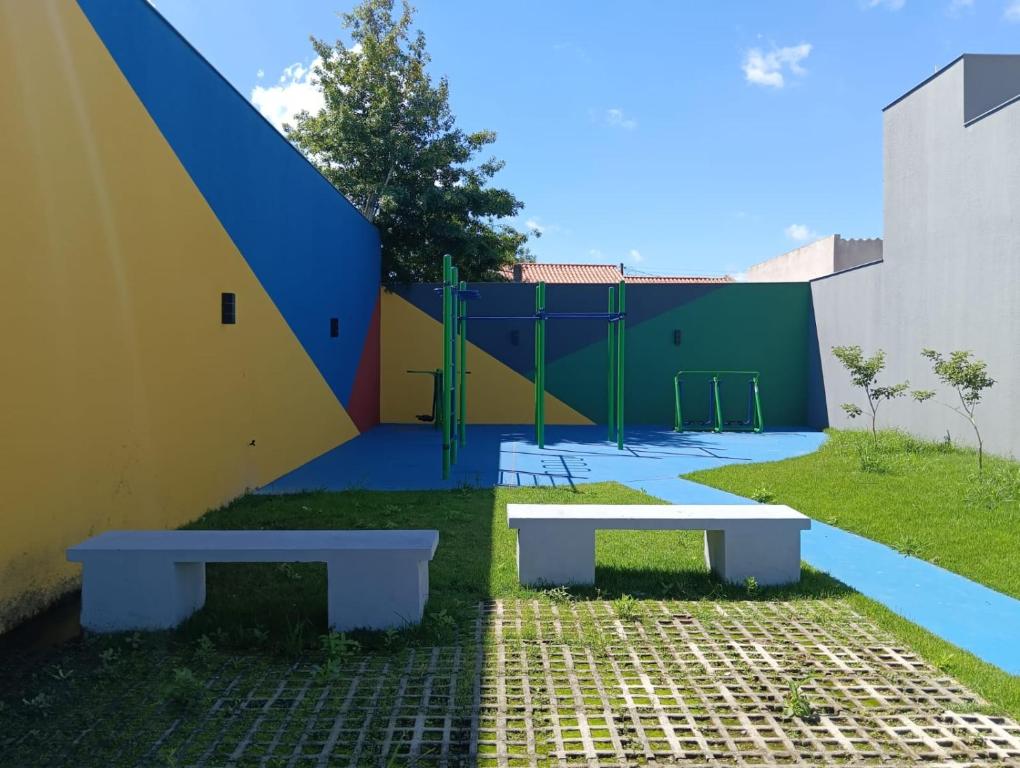 two benches sitting in front of a playground at Loft Noruega 32 AC Garagem Privativa in Jaguarão