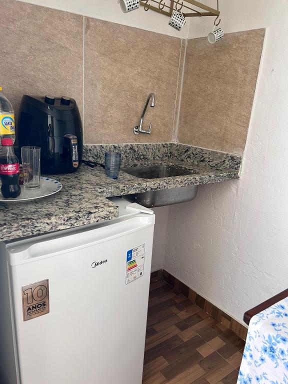a small kitchen with a sink and a refrigerator at Quarto do Poeta 